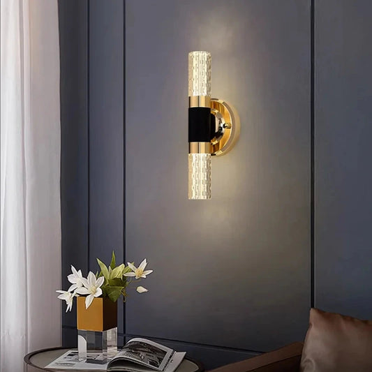  mounted on a bathroom wall, featuring a golden base with bubble-textured acrylic light tubes.