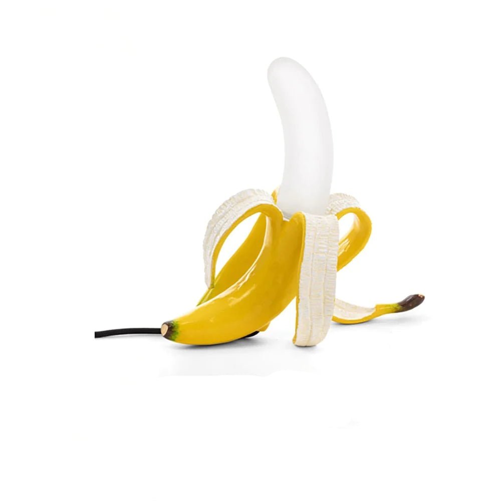  J.Y.R® Banana LED Table Lamp - Modern minimalist lamp with glass shade and resin base, positioned in a stylish living room.